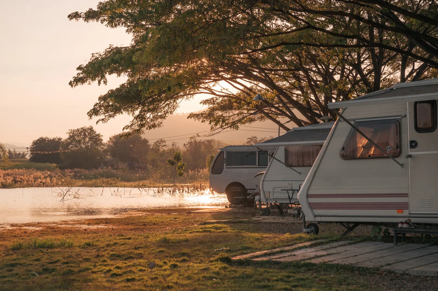 Touring caravans at a waterside campsite in evening light
