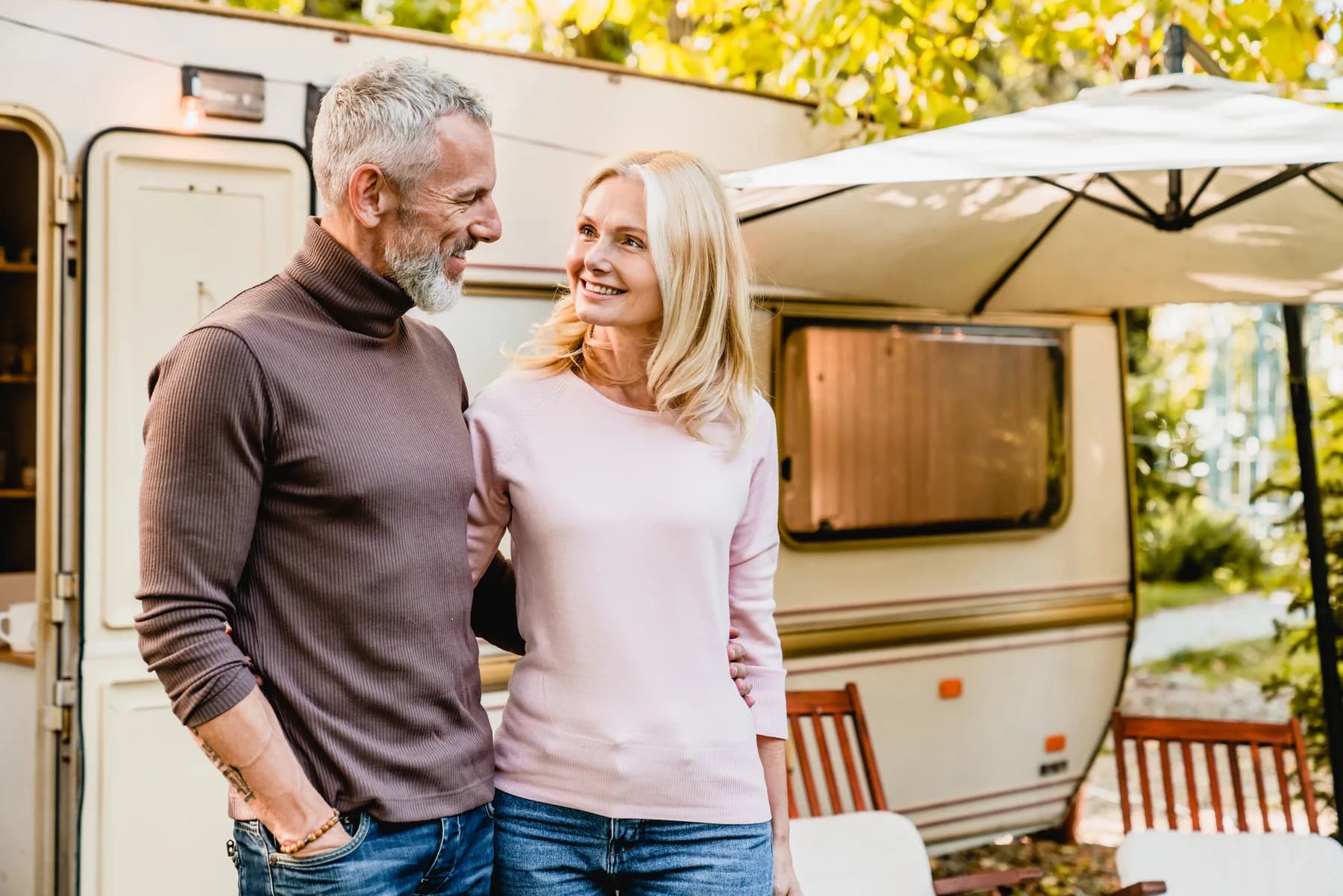 A couple beside a touring caravan, used to illustrate caravan buying research