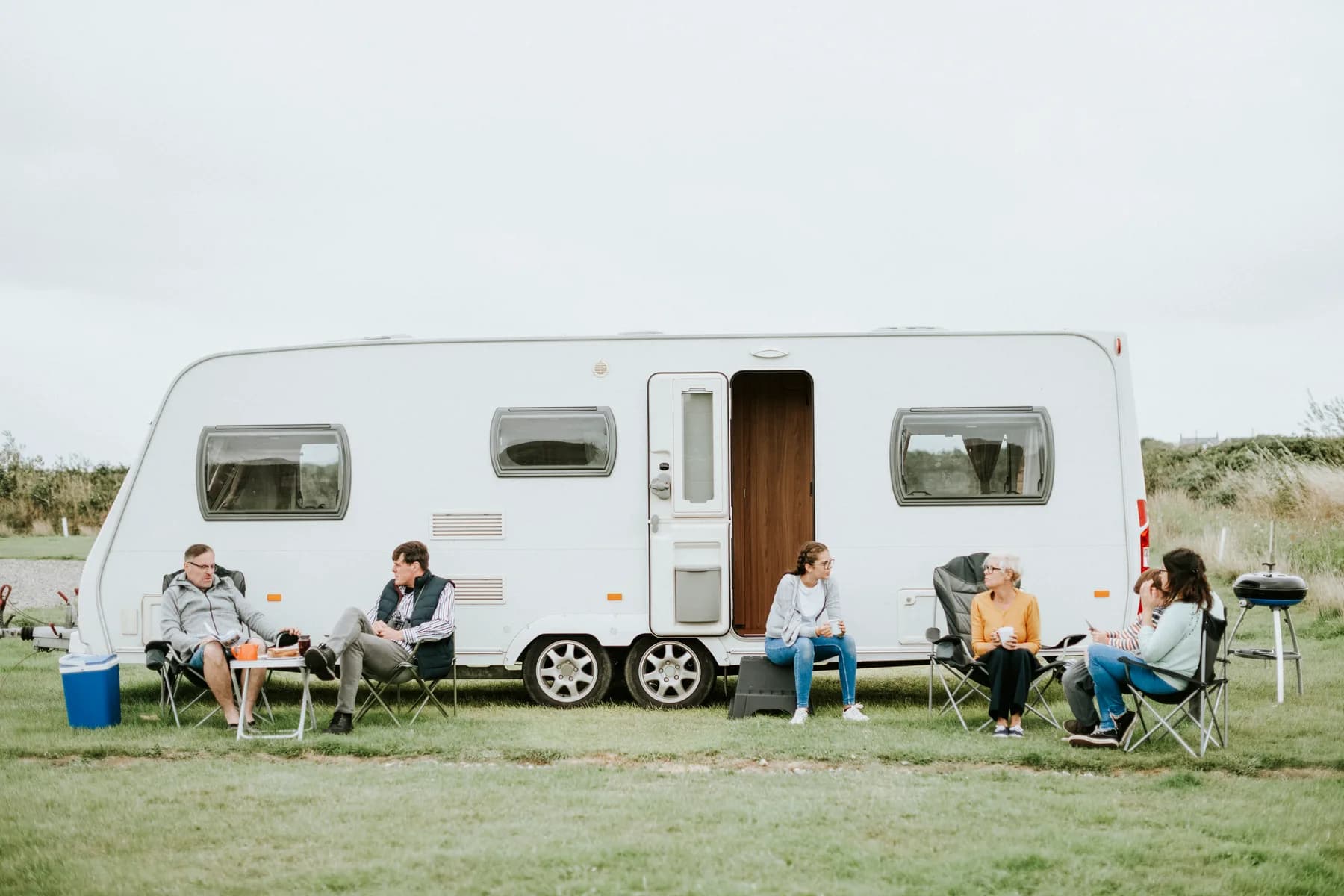 Friends sitting together outside a touring caravan