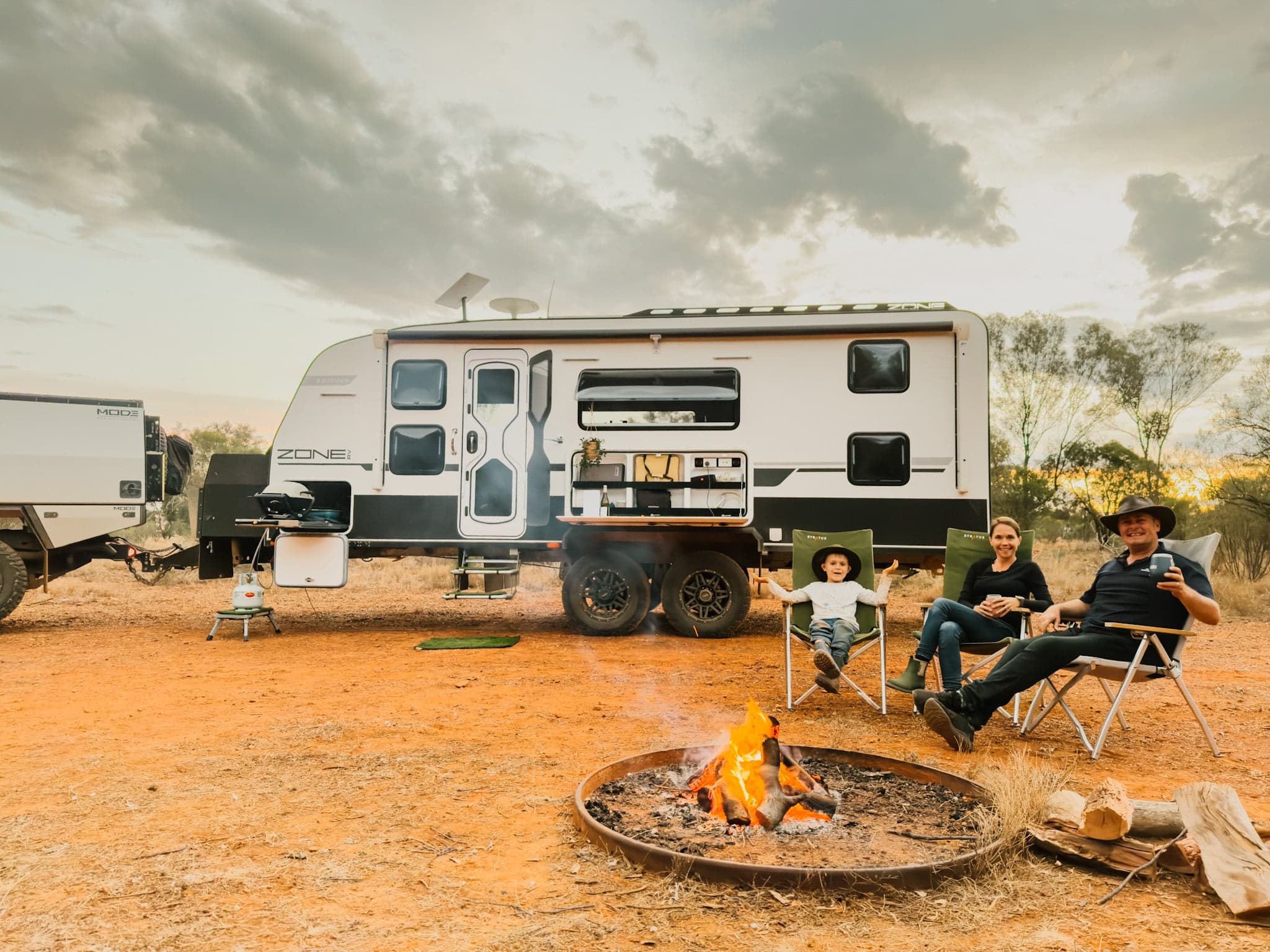 Zone RV Sojourn Family at an outdoor camp with a family seated in front